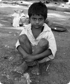 Young boy living rough on dusty streets