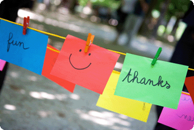 A washing line with postit notes attached - one postit showing a smiley face - another reads thank you