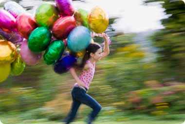 Young girl running with a lots of helium balloons