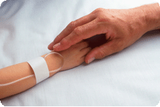 Parent's hand holding sick child's hand